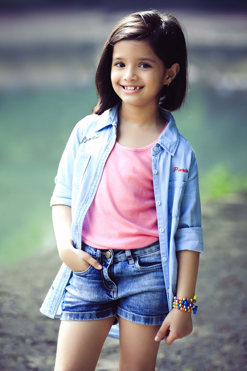 Free Photos - A Young Girl With Big Eyes And Curly Hair Wearing Blue  Overalls. She Stands Out In The Picture As She Poses In Front Of A Blue  Background, Looking Directly